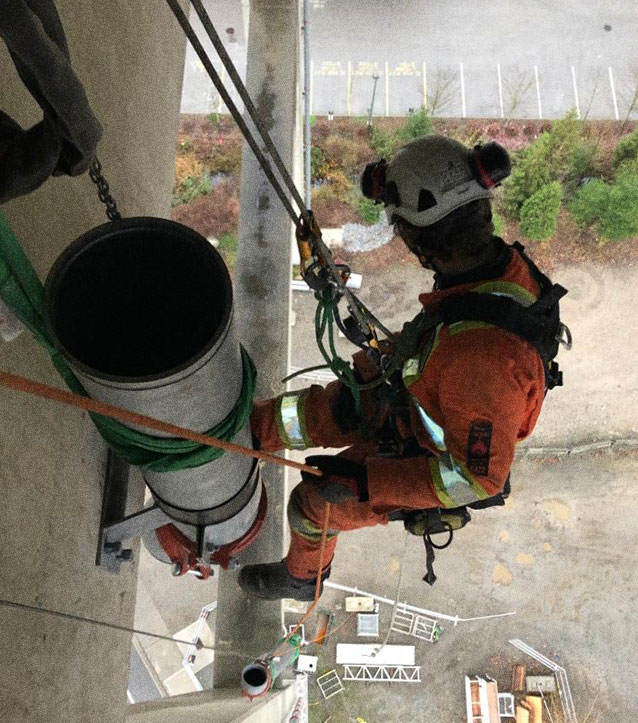 rope access rigging, man rigging while attached to rope.